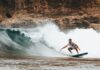 Tag til Hawaii og lev det eksotiske surfer liv Person surfer på surfboard i hawaii