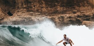 Tag til Hawaii og lev det eksotiske surfer liv Person surfer på surfboard i hawaii
