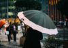 Kvinde går med paraply i byen