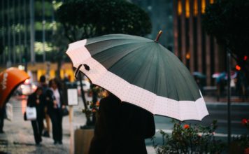 Kvinde går med paraply i byen