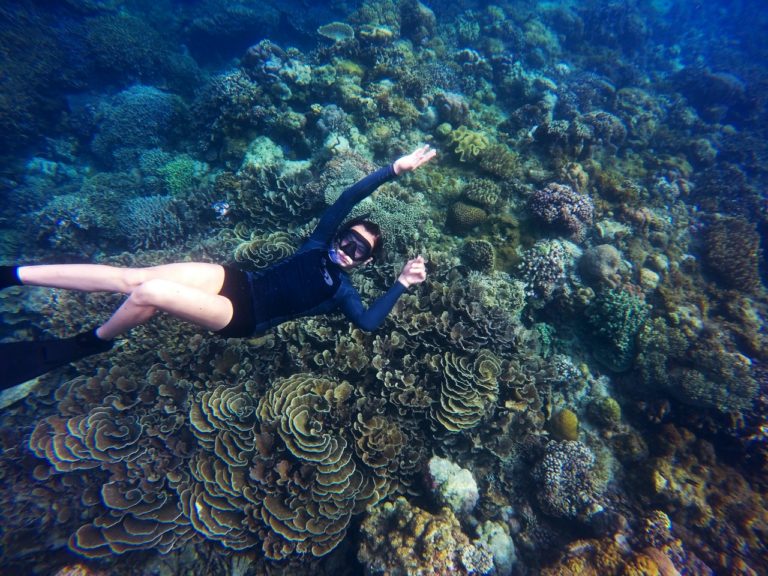 Person svømmer rundt om koralrev med snorkel