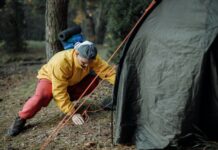En varm kop Rooibush te er godt på campingturen Mand er i gang med at sætte telt op